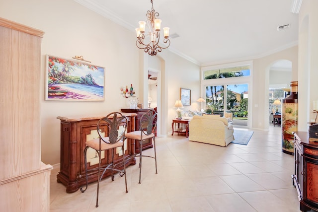 interior space with a notable chandelier, light tile patterned flooring, ornamental molding, and bar area