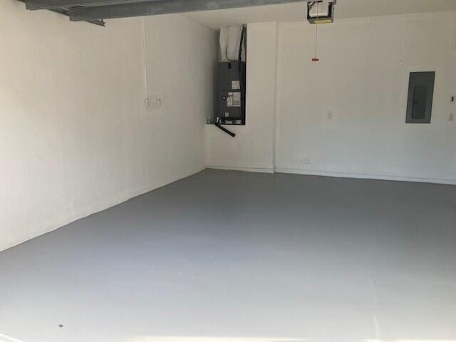 garage with electric panel, heating unit, and a garage door opener