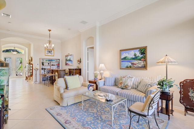 tiled living room with crown molding, french doors, and an inviting chandelier