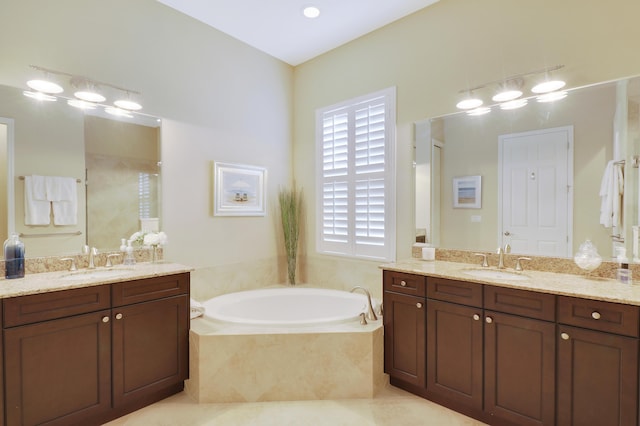 bathroom with tile patterned floors, tiled tub, and vanity