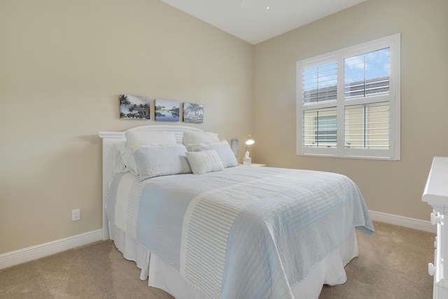 bedroom featuring baseboards and light colored carpet