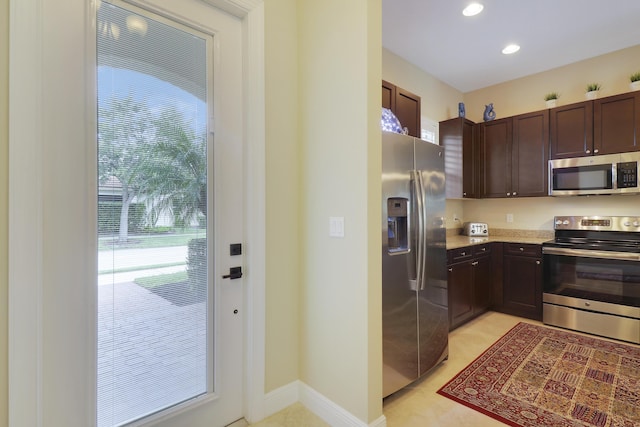 kitchen featuring dark brown cabinetry, appliances with stainless steel finishes, light countertops, and light tile patterned flooring