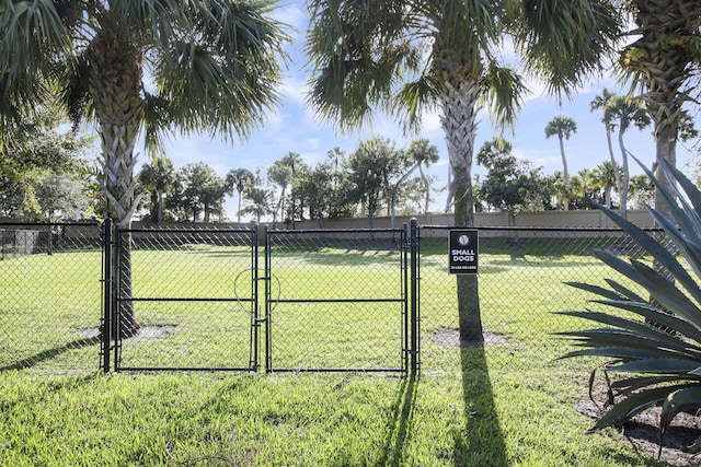 view of gate featuring a lawn and fence