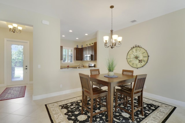 dining area with baseboards, visible vents, and a chandelier