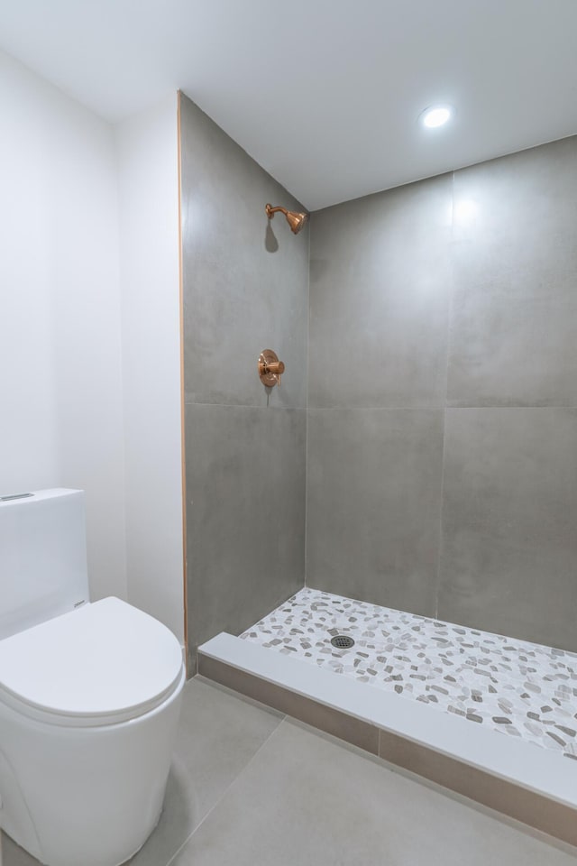 bathroom featuring a shower, tile patterned flooring, and toilet