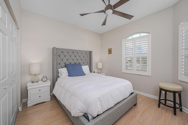 bedroom with ceiling fan, a closet, and light hardwood / wood-style flooring