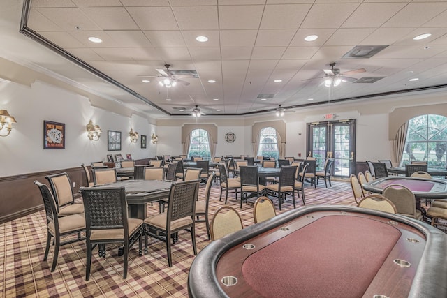 carpeted dining space featuring ceiling fan, french doors, a healthy amount of sunlight, and ornamental molding