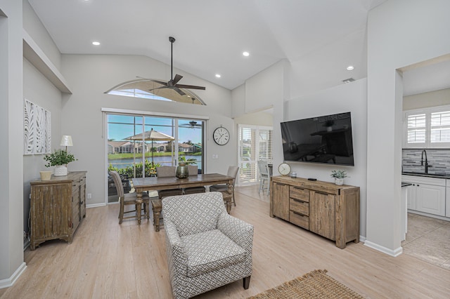 living room with ceiling fan, light hardwood / wood-style floors, sink, and a wealth of natural light