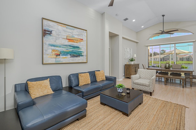 living room with ceiling fan, wood-type flooring, and lofted ceiling