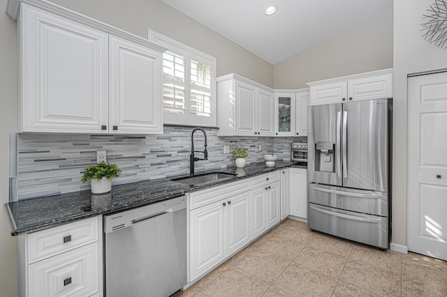 kitchen with stainless steel appliances, sink, white cabinets, lofted ceiling, and light tile patterned flooring