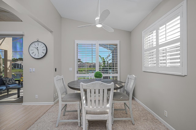 dining space featuring ceiling fan, light hardwood / wood-style flooring, and vaulted ceiling