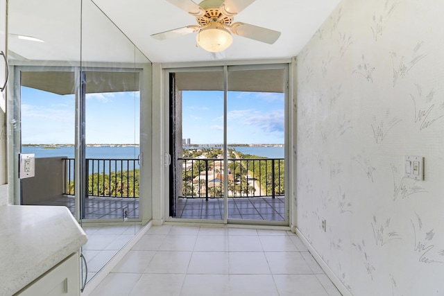 unfurnished sunroom with a water view and ceiling fan