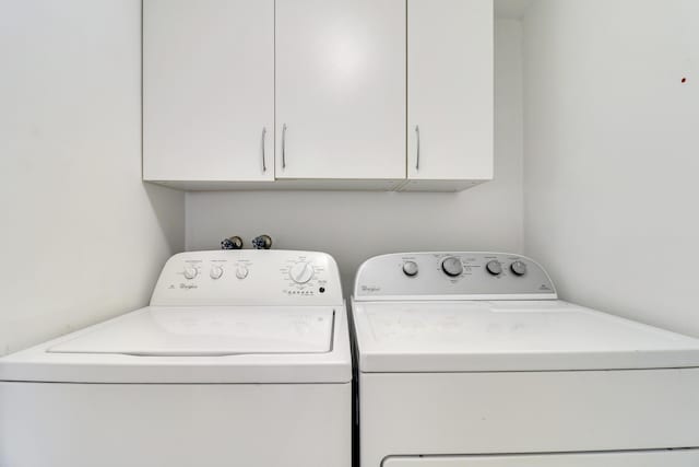 washroom featuring cabinet space and independent washer and dryer