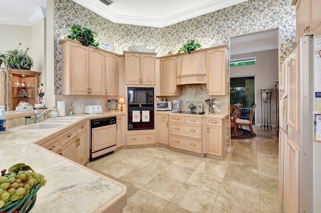 kitchen with black appliances, custom exhaust hood, light brown cabinets, and sink