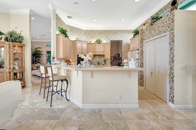 kitchen with light brown cabinets, white refrigerator with ice dispenser, kitchen peninsula, crown molding, and a kitchen bar