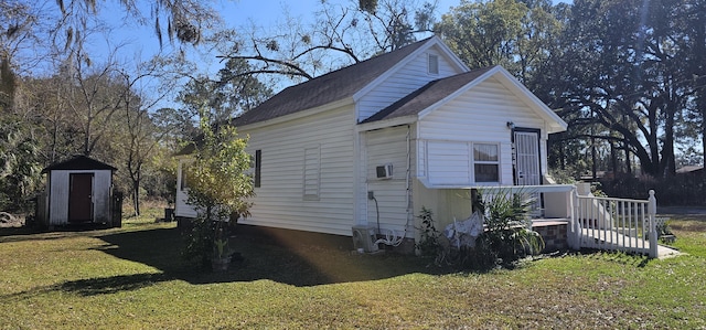 view of side of home featuring a lawn and a storage unit