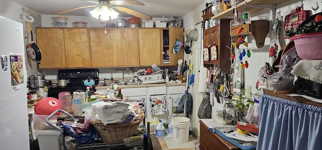 kitchen featuring ceiling fan, black electric range oven, sink, and white fridge