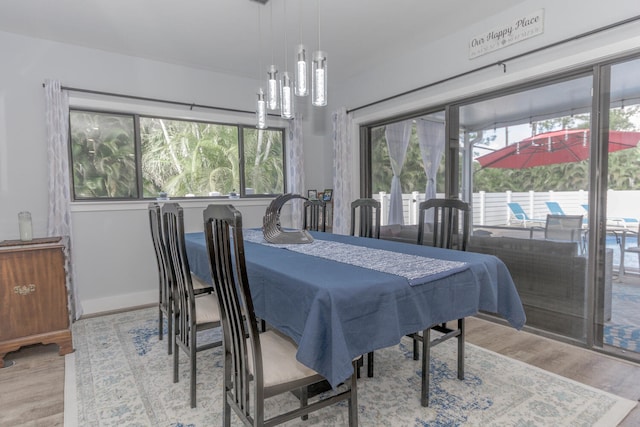 dining space featuring wood-type flooring and a notable chandelier