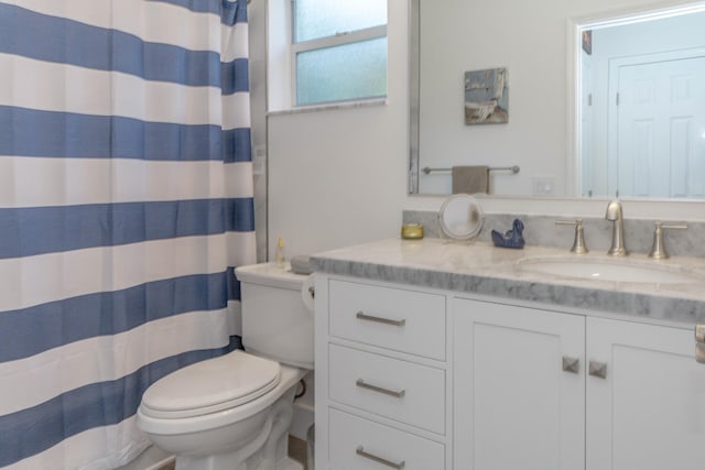 bathroom featuring a shower with curtain, vanity, and toilet