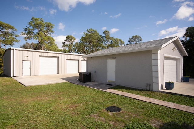 garage with a yard and central AC unit