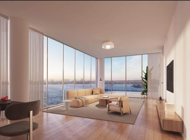 living room featuring a water view, light hardwood / wood-style floors, and a wall of windows