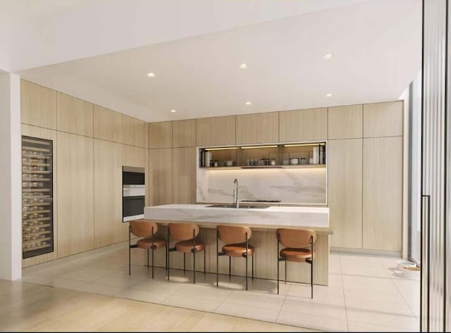 kitchen featuring a kitchen breakfast bar, a center island with sink, and light tile patterned floors