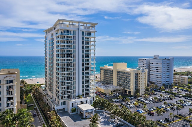 view of building exterior featuring a water view and a view of the beach