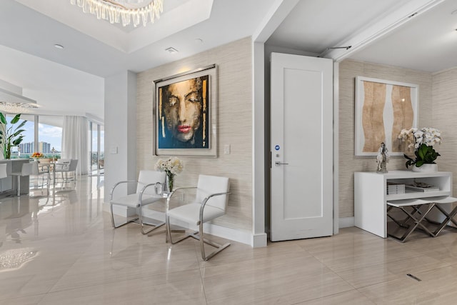 hallway with light tile patterned floors and an inviting chandelier