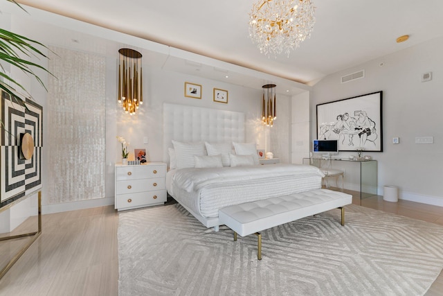 bedroom featuring an inviting chandelier and light hardwood / wood-style flooring