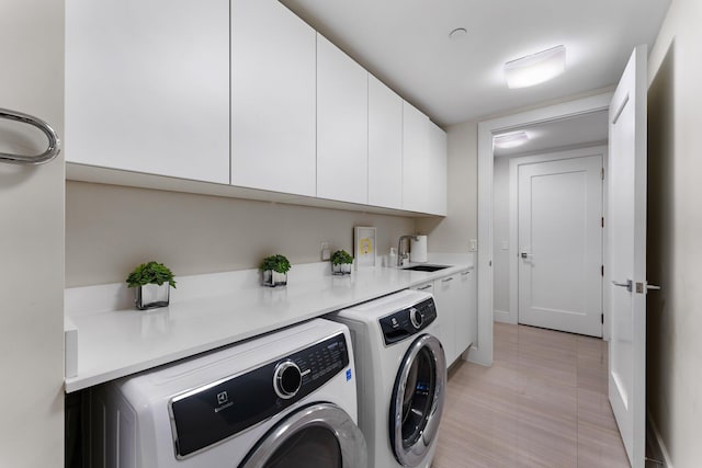 washroom with sink, light tile patterned flooring, cabinets, and washing machine and clothes dryer