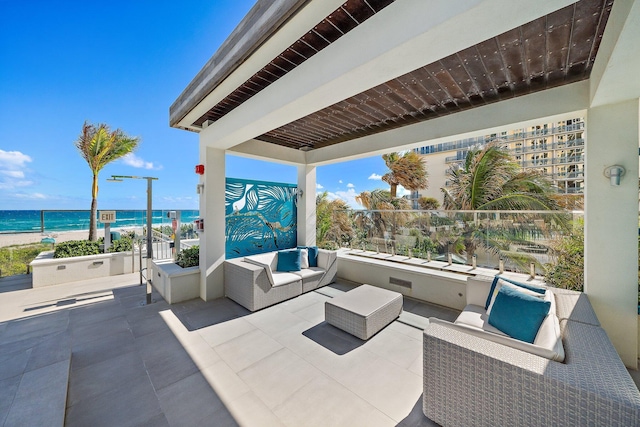 view of patio featuring an outdoor living space, a water view, and a beach view