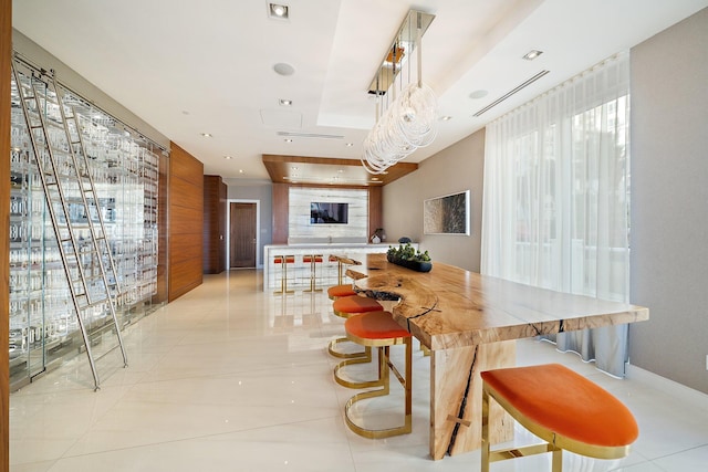 dining space with light tile patterned floors and a raised ceiling