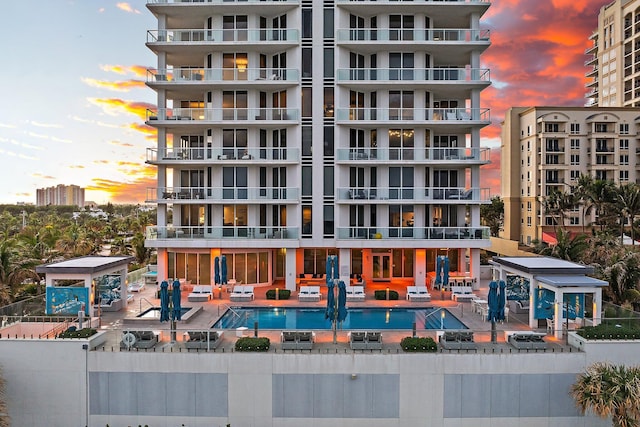 outdoor building at dusk featuring a community pool