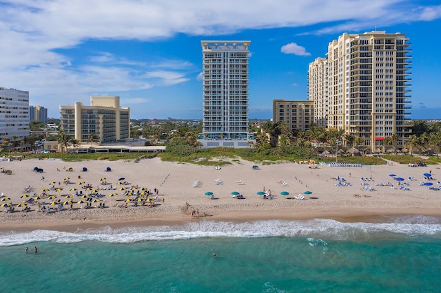 birds eye view of property with a water view and a beach view