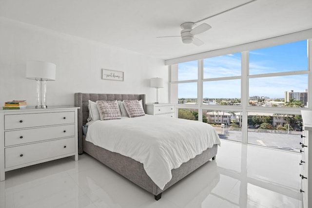 bedroom featuring light tile patterned floors, a wall of windows, and ceiling fan