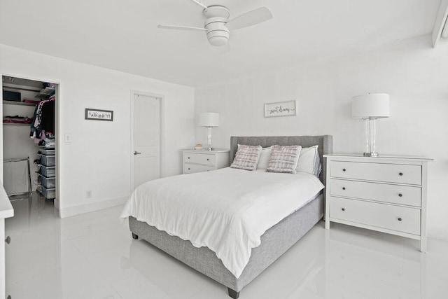 bedroom with a walk in closet, ceiling fan, and a closet