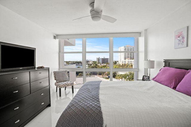 bedroom with a wall of windows and ceiling fan