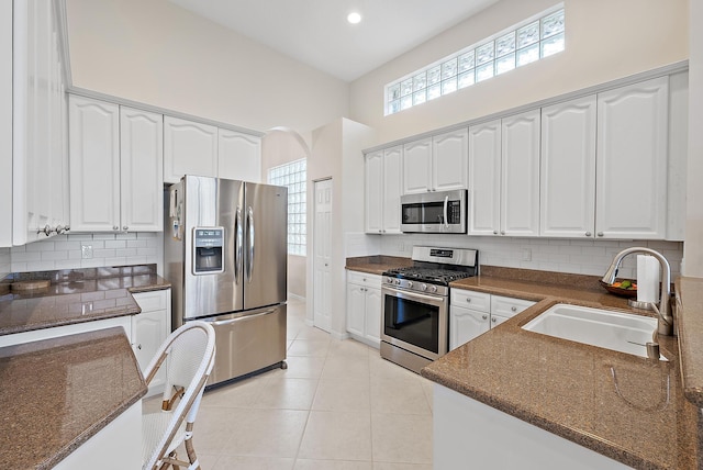 kitchen featuring light tile patterned floors, stainless steel appliances, white cabinetry, and sink