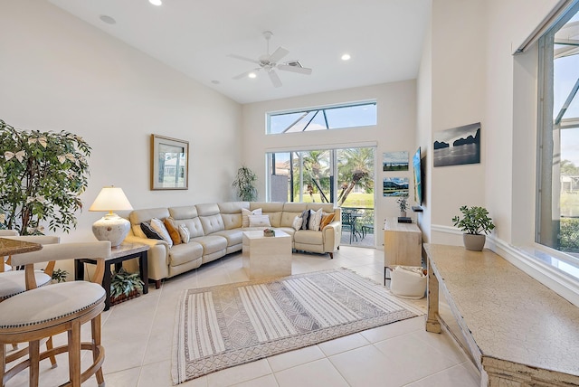 living room featuring ceiling fan, light tile patterned floors, and a high ceiling