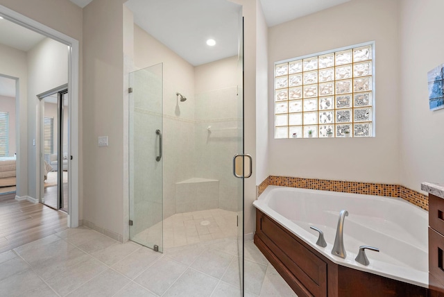 bathroom featuring tile patterned floors, vanity, and shower with separate bathtub