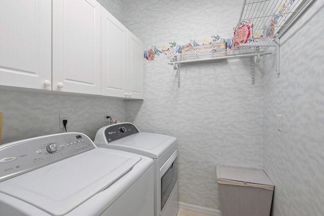 clothes washing area with cabinets and washing machine and clothes dryer