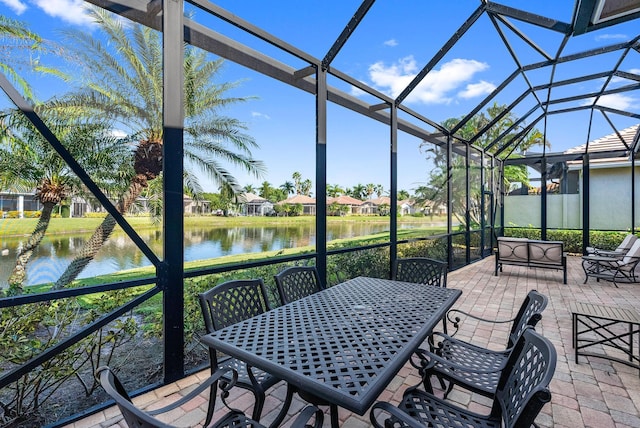 sunroom featuring a water view