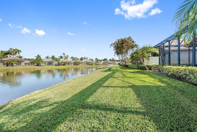 view of yard with a lanai and a water view