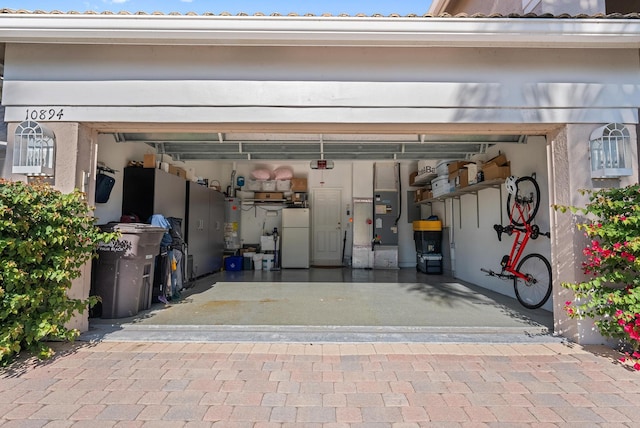 garage with gas water heater and white refrigerator