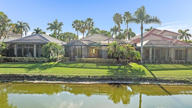 back of house featuring a yard and a water view