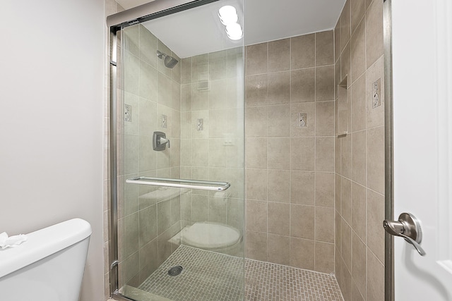 bathroom featuring a shower stall and toilet