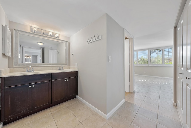 full bathroom featuring double vanity, tile patterned flooring, and a sink