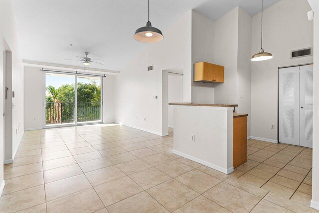 interior space with ceiling fan, high vaulted ceiling, and light tile patterned floors