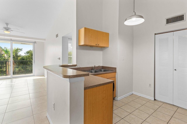 kitchen featuring sink, decorative light fixtures, light tile patterned floors, and kitchen peninsula