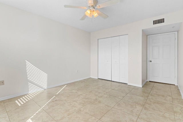 unfurnished bedroom with light tile patterned floors, a closet, and ceiling fan